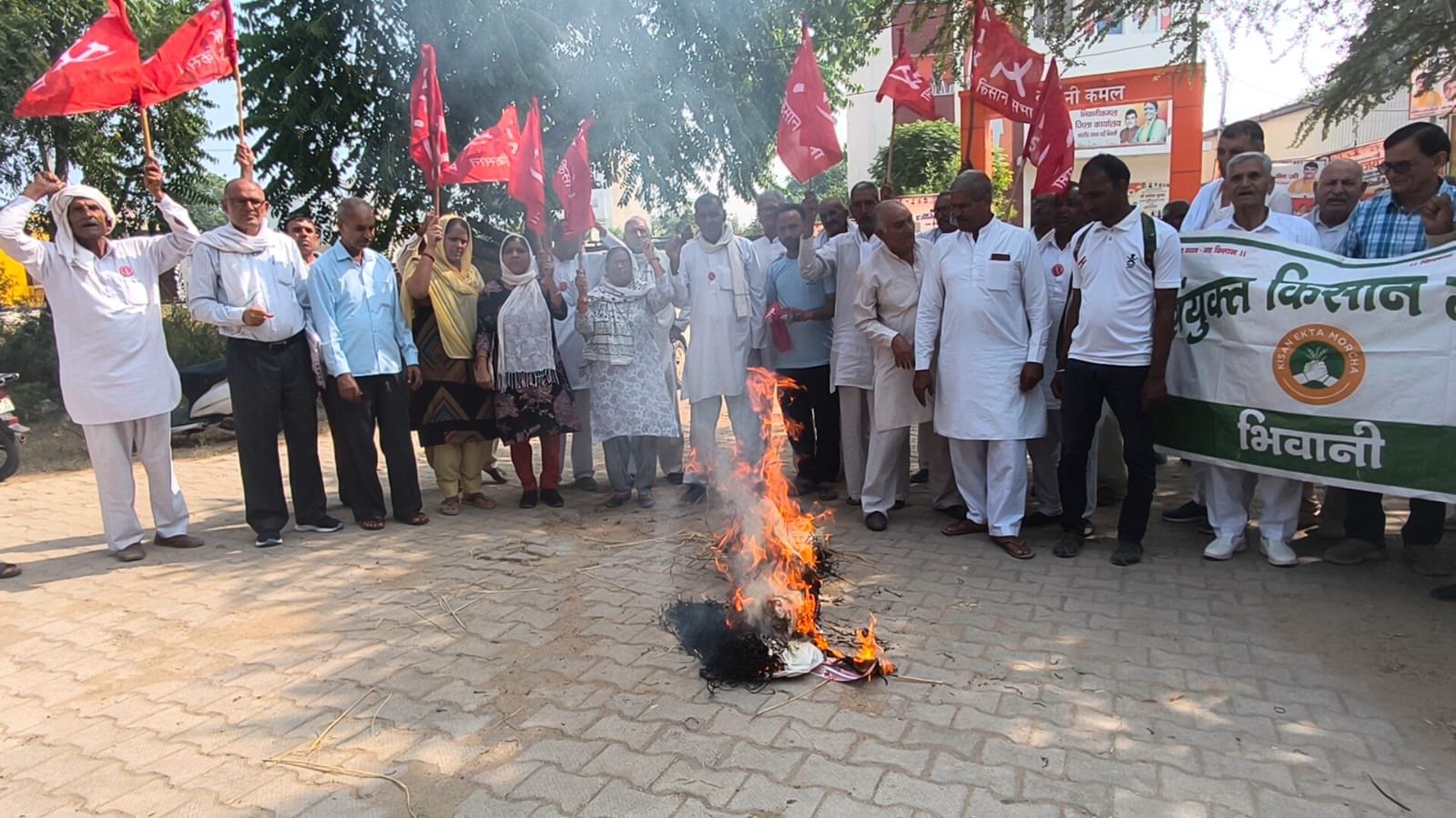 भाजपा कार्यालय के बाहर सरकार का पुतला फूंकते किसान।
