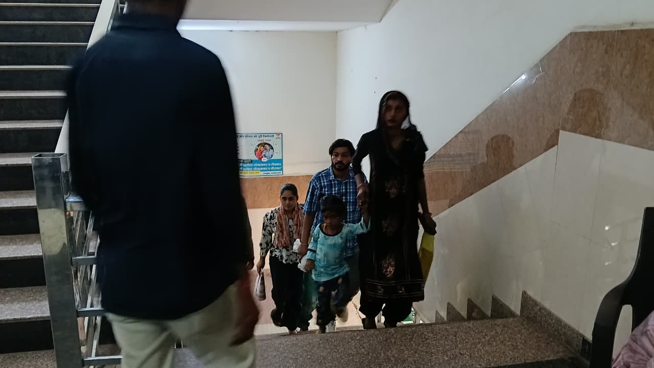 अस्पताल में दूसरी मंजिल पर जाने के लिए सीढिया चढ़ते मरीज। 