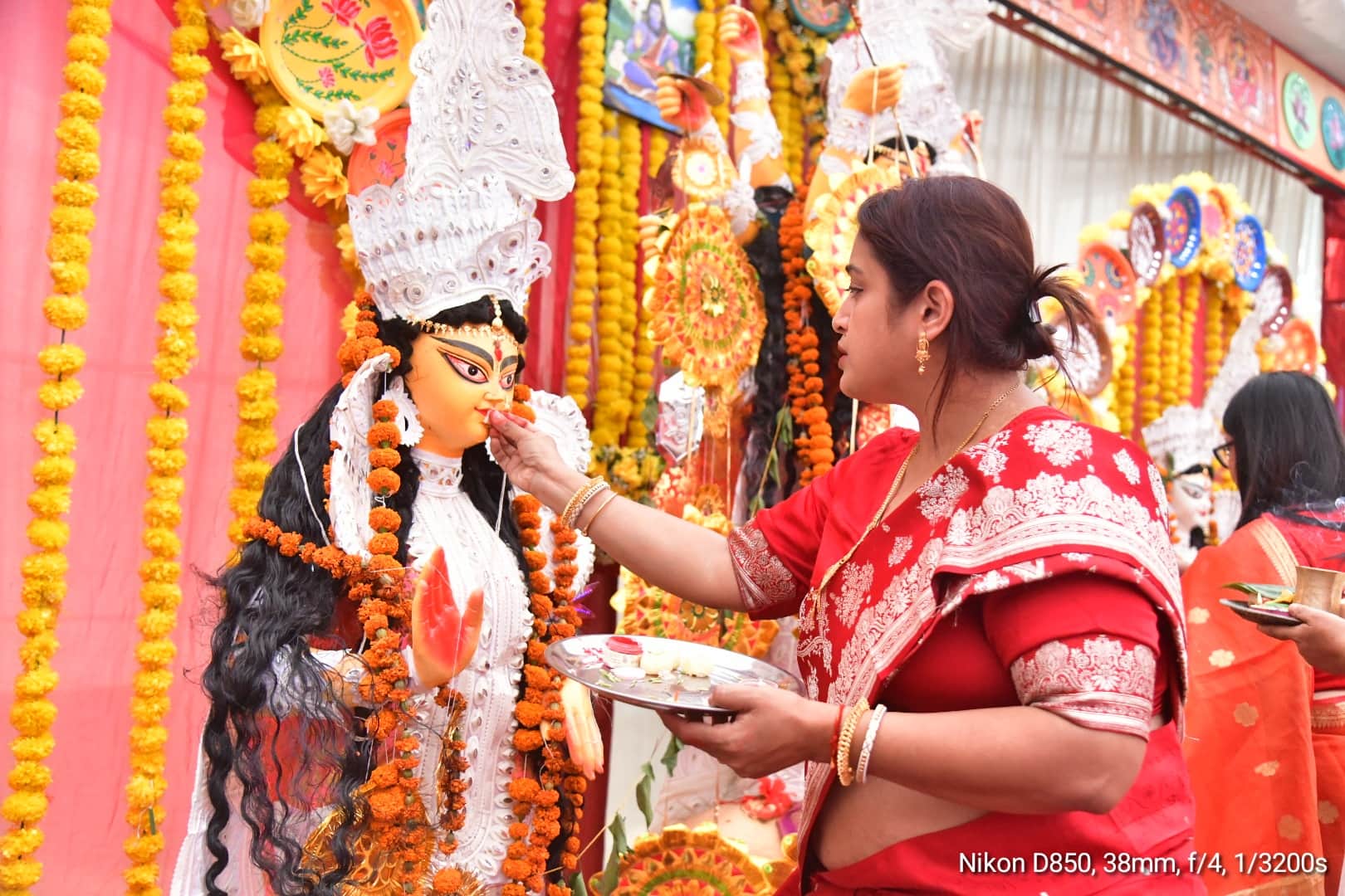 दुर्गा महोत्सव में मां की आरती करती महिला। 