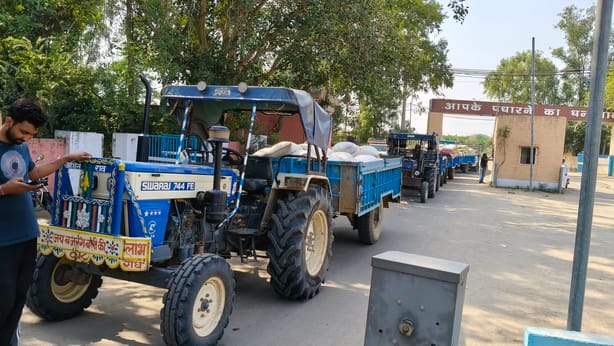 दादरी के नई अनाज मंडी में लगी ट्रैक्टर की कतारें मंडी में किसान का गेट पास काटते हुए कर्मचारी