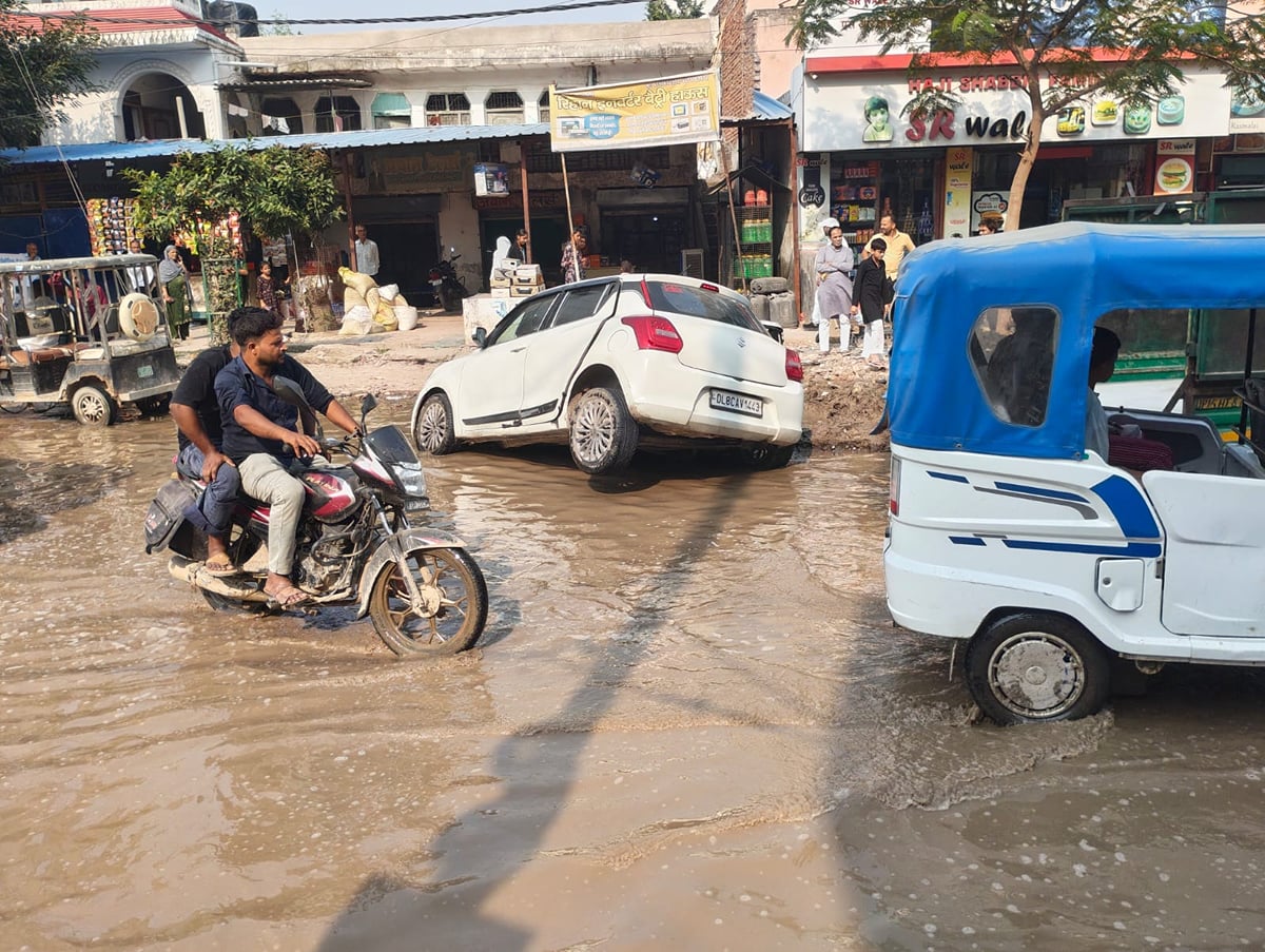 Noida News: सड़क पर जलभराव, गड्ढे में फंसी कार