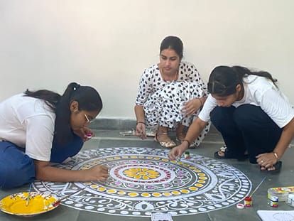 युवा महोत्सव की तैयारियों के दौरान रंगोली बनातीं छात्राएं। संवाद