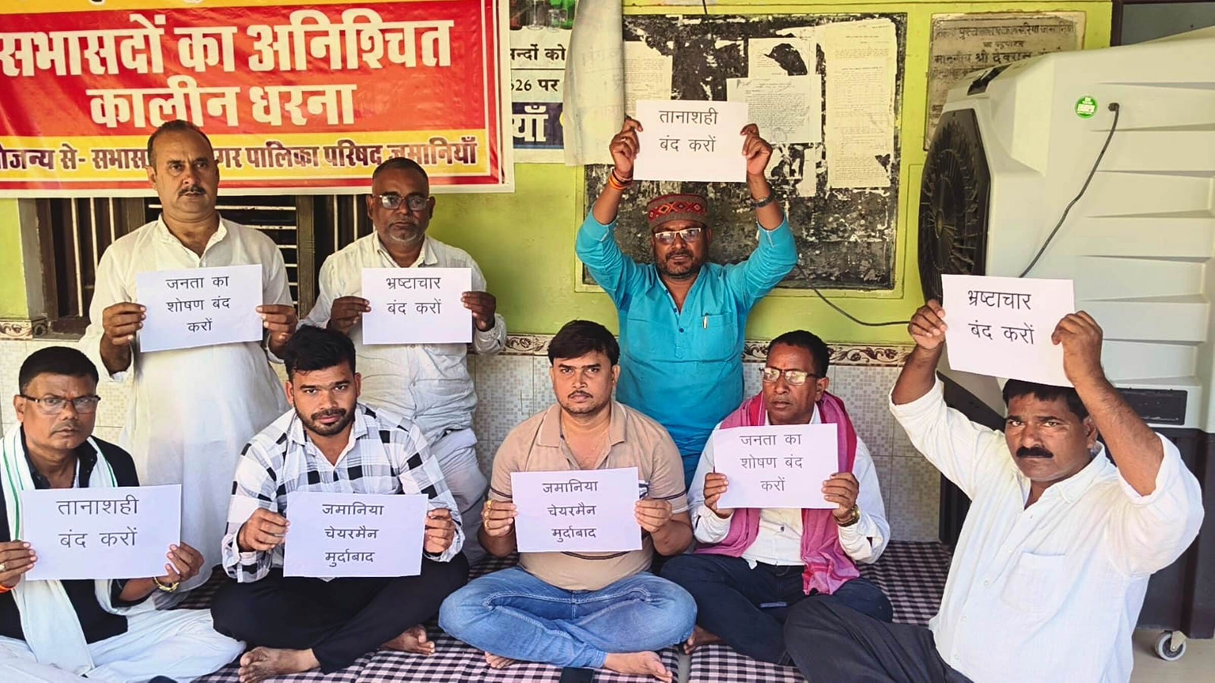 जमानिया नगर पालिका कार्यालय के बरामदे में धरने पर बैठे सभासदगण। संवाद