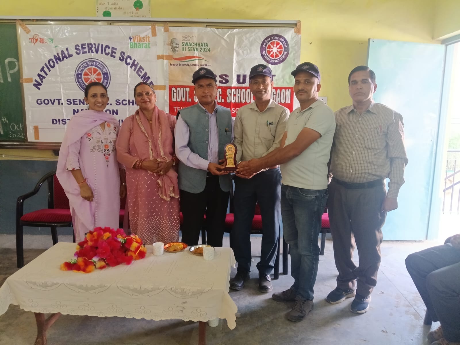 नवगांव में एनएसएस शिविर के शुभारंभ समारोह में मौजूद मुख्य अतिथि, विशेष अतिथि और विद्यालय प्रबंध