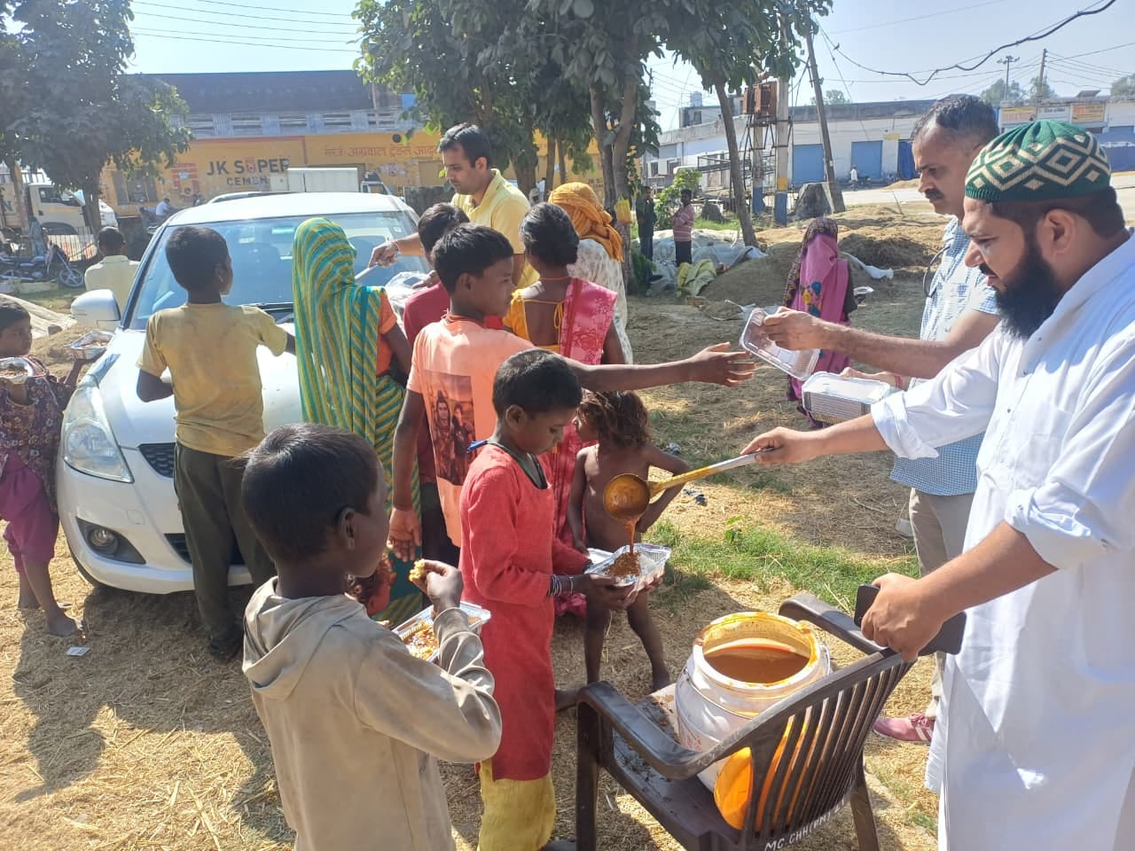 प्रतापनगर अनाज मंडी में भोजन वितरित करते ट्रस्ट के पदाधिकारी। संस्था
