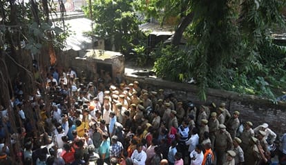 हत्या के आरोपी के घर में घुसे लोगों को निकालती पुलिस। 