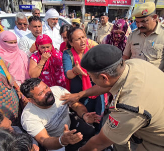 तनातनी... परिजनों के विरोध के बीच प्रदर्शनकारी को समझाते पुलिसकर्मी।अमर उजाला