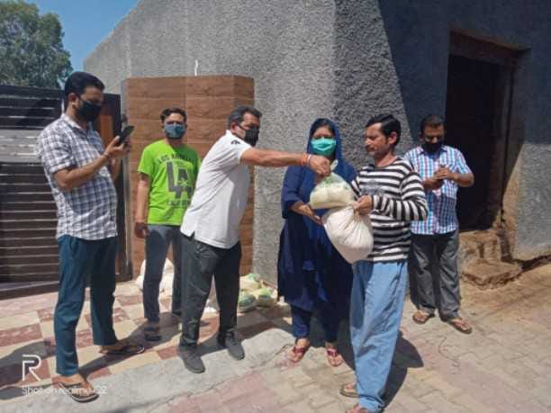 youngster distribute food items among needy people of village