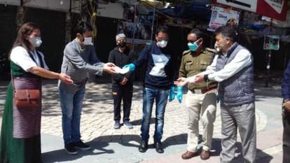 एसडीएम को चैक सौंपते तिब्बती समुदाय के लोग