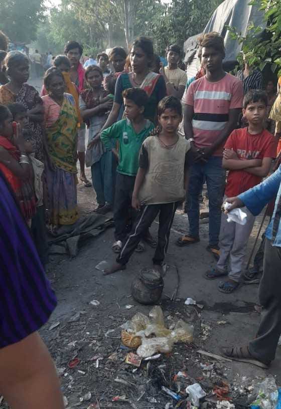 Slum dwellers near the railway gate put food packets in garbage