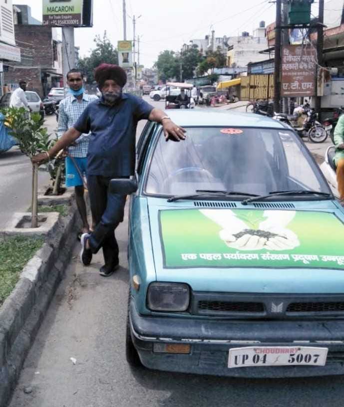 रुद्रपुर में डिवाइडर पर लगाए पौधों को पानी देते मनमोहन सिंह।