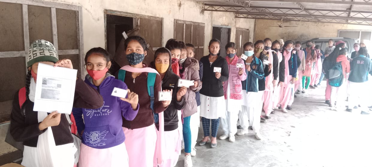 कोरोना वैक्सीन लगवाने के लिए लाइन में लगी स्कूल की छात्राएं।