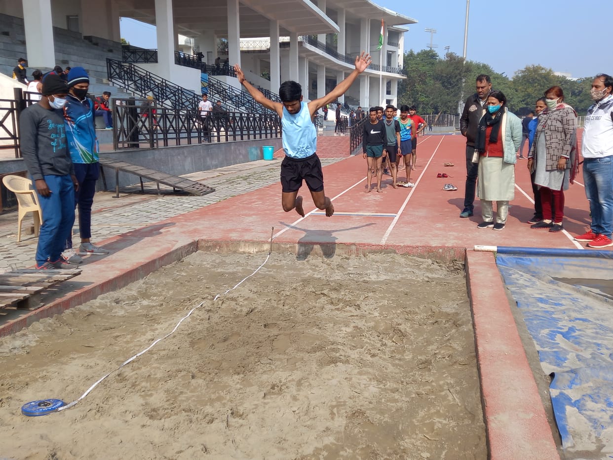 नेहरू स्टेडियम में खिलाड़ियों की आवासीय खेल अकादमी के लिए ताऊ देवीलाल खेल परिसर में एथलेटिक्स ट्रायल में लंबी कूद का ट्रायल देता  खिलाड़ी।
