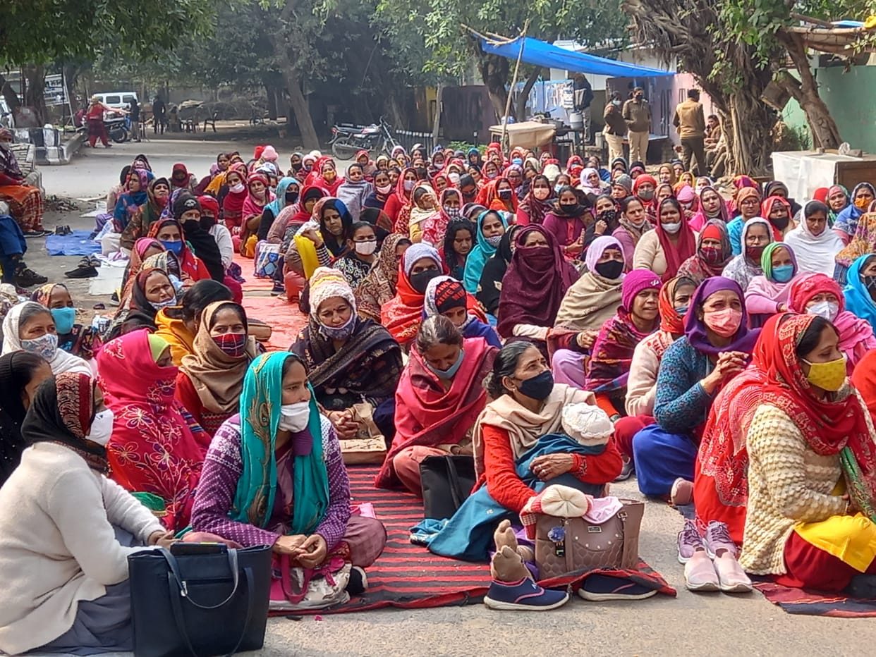 विकास सदन के गेट के सामने अपनी मांगों को लेकर धरने पर बैठी आंगनबाड़ी कार्यकर्ता महिलाएं।