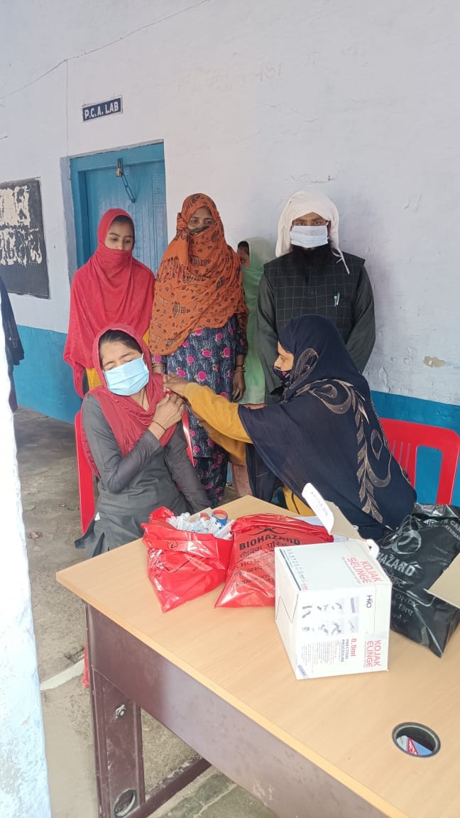 फ़ोटो पुन्हाना गर्ल्स स्कूल में स्वास्थ्य कर्मी कोरोना का टीका लगाते हुए