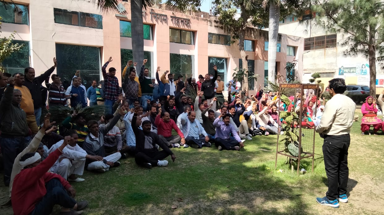 नगर निगम कार्यालय में अपनी मांगों को लेकर धरने पर बैठे कर्मचारियों को संबोधित करते प्रधान संजय बिड़लान