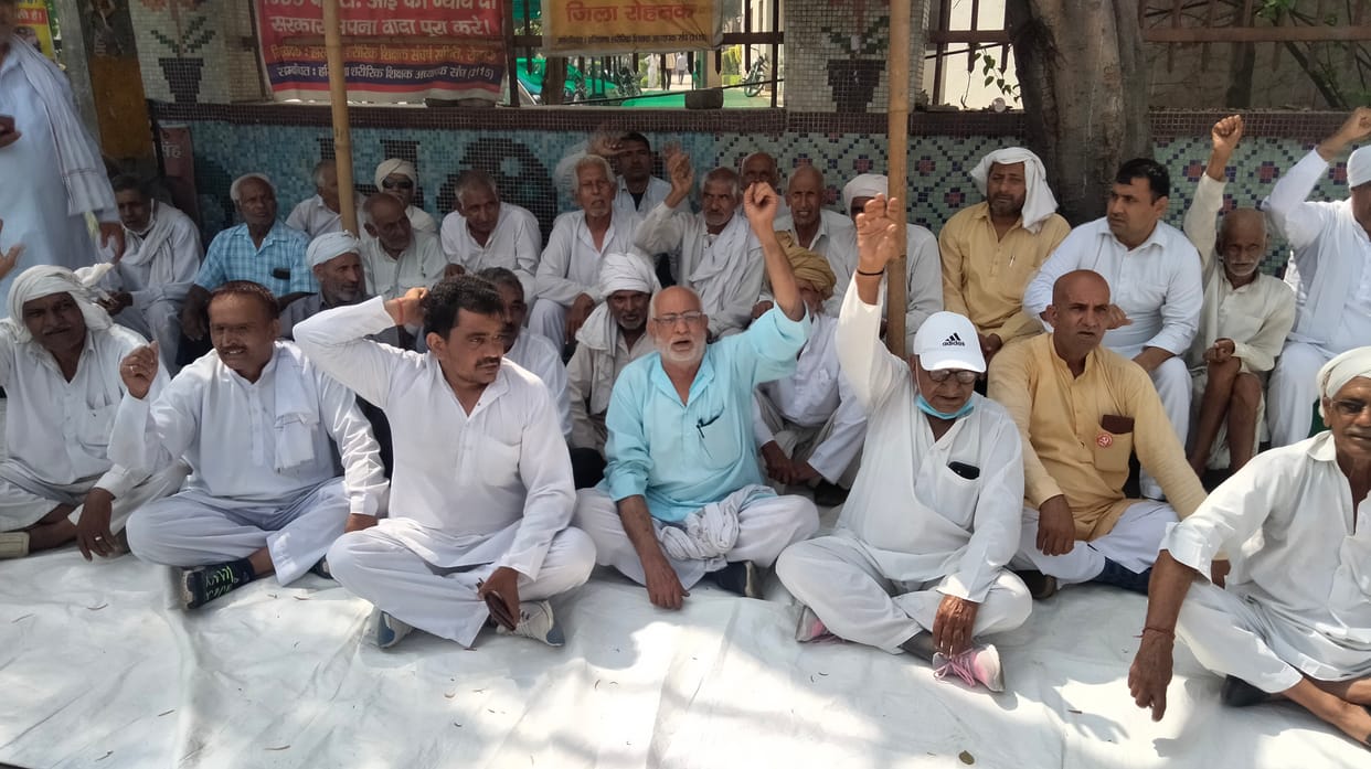 लघु सचिवालय के सामने गेट पर अपनी मांगों को लेकर धरने पर बैठे किसान। संवाद