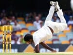 Varun Aaron falls over while bowling to Warner.