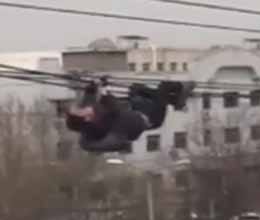 Drunken man dangles from power cables in china