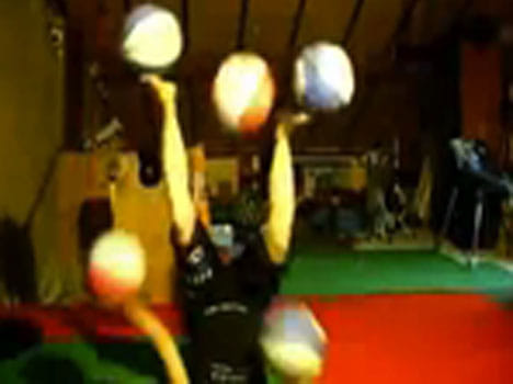 girl juggles with five basketball at a time