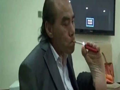 man threads eye of a needle with his toes
