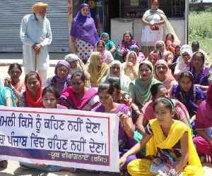 Women sitting on a dharna to stay off alcohol contract