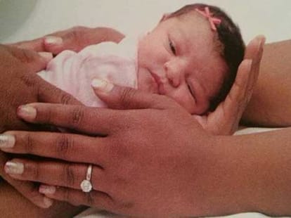 mother tied newborn to her gown on wedding day