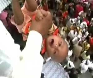 babies being tossed from atop for good luck