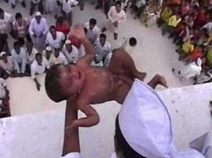 babies being tossed from atop for good luck