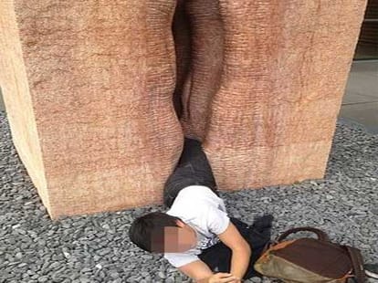 man stuck inside stone sculpture depicting vagina