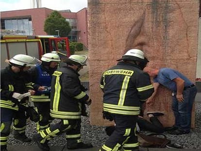 man stuck inside stone sculpture depicting vagina