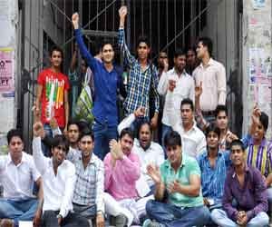 College students hit the lock on the gate, sitting on dharna