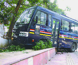 Police bus rams in roadside wall.