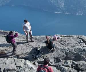 parents lets child sit a corner on a cliff