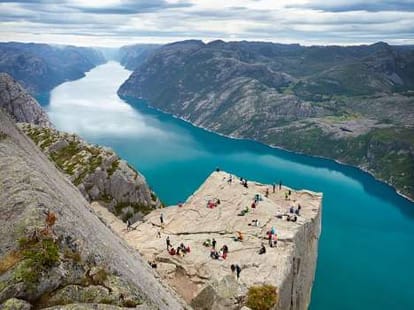 parents lets child sit a corner on a cliff