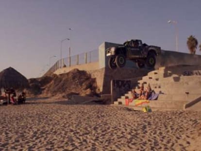 daredevil racing driver drives jumps over bikini clad girls