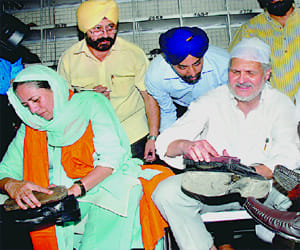 LG polishes shoes with wife in bangla sahib.