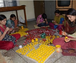 destitute women illuminating Others Diwali 