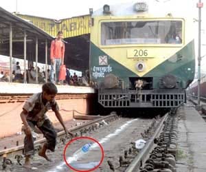 Children picking up litter on train tracks.