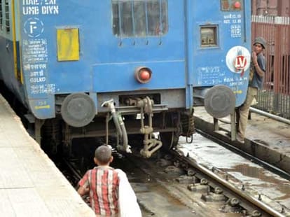 Children picking up litter on train tracks.