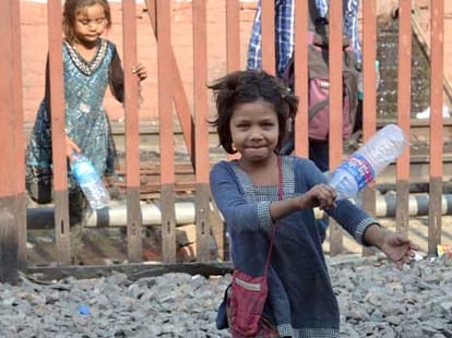 Children picking up litter on train tracks.