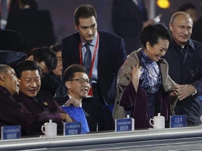 Putin caught on camera placing shawl China's first lady.