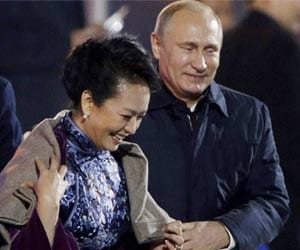 Putin caught on camera placing shawl China's first lady.
