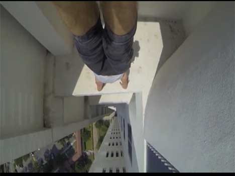 acrobat does a handstand on the edge of 24 storey building