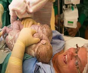 mother reaches her tummy and pulls out twins