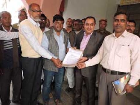 teacher handing over a memorandum to the district magistrate