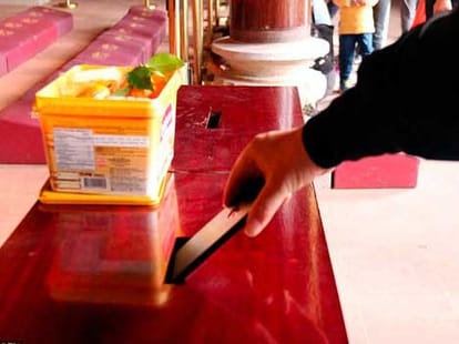 man donates his iphone in temple
