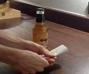 opening a beer bottle with a  paper
