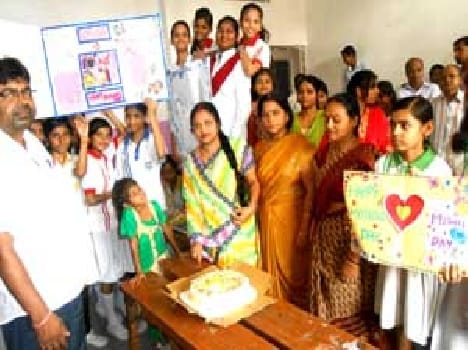 Paintings made by children on Mother's Day and a cut cake