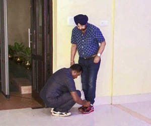 Security personnel ties the shoelaces of TMC minister